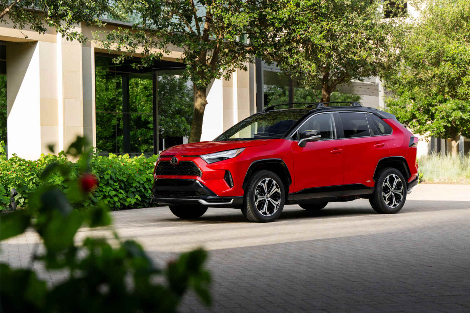 A red 2025 Toyota RAV4 PHEV parked in far left front angle view