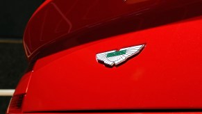 Ceramic Aston Martin badge on the trunk of a red sports car.