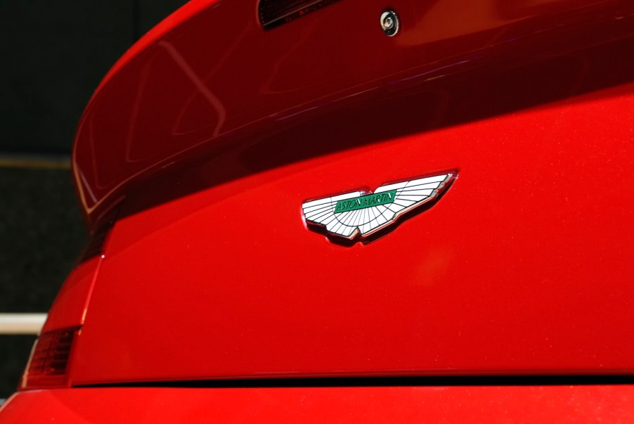 Ceramic Aston Martin badge on the trunk of a red sports car.