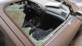 Broken passenger window in a car from a break-in crime spree.