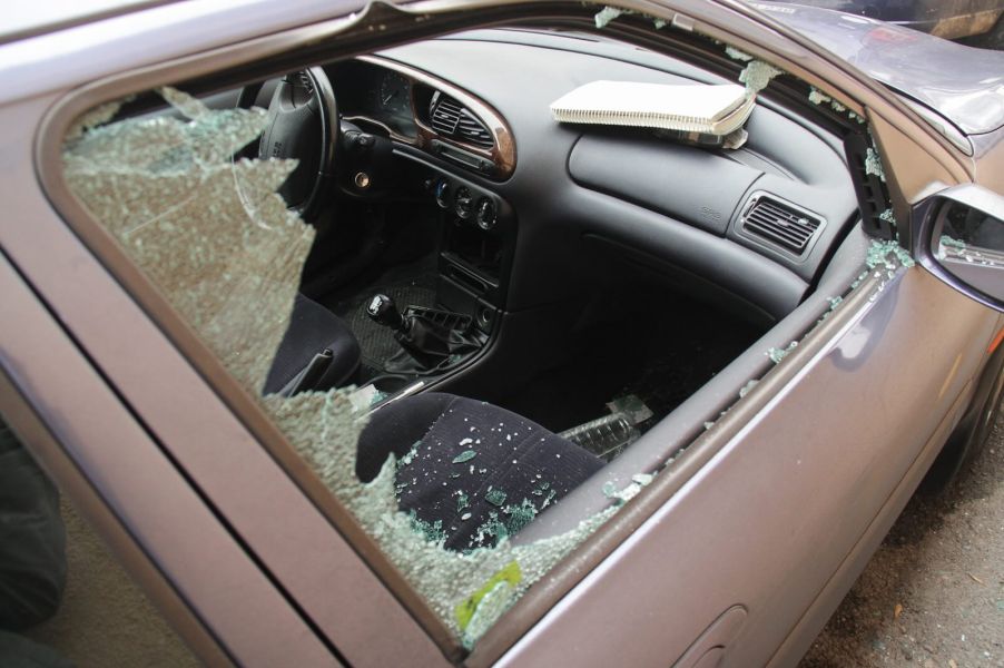 Broken passenger window in a car from a break-in crime spree.
