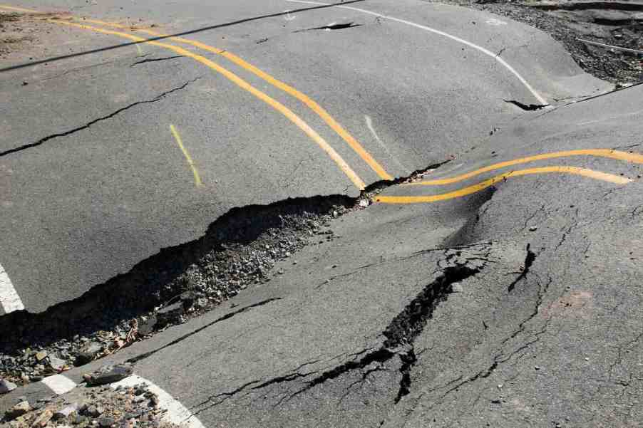 Road's asphalt surface buckles and breaks during heat wave.