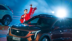 Chinese singer waves from the stage during the Cadillac XT4 launch in China, a crossover SUV next to her.