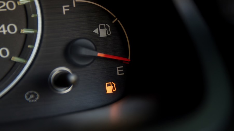 Bright yellow low fuel warning light below empty gas tank gauge.