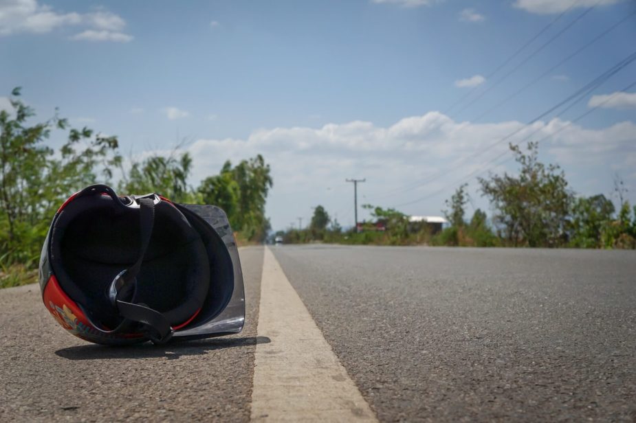 A helmet sits next to the road shoulder after a bad motorcycle crash.