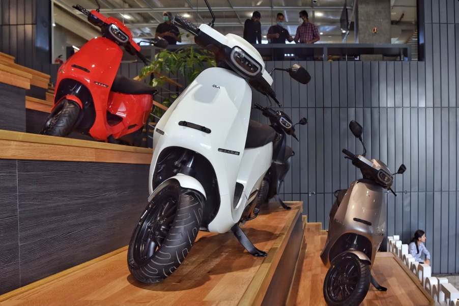 A row of electric scooters in an Ola display room.