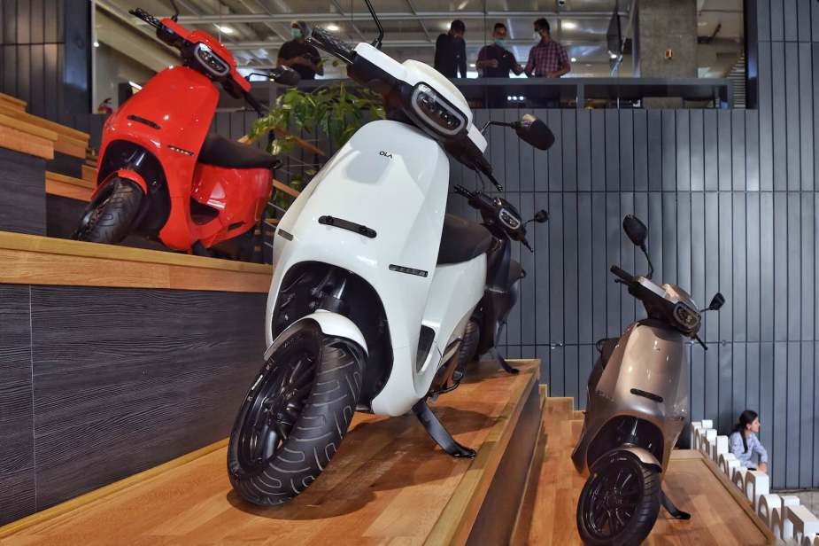 A row of electric scooters in an Ola display room.