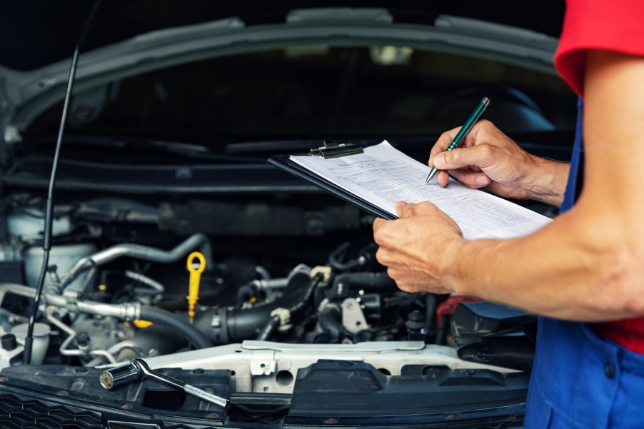 Mechanic completes a state safety emissions vehicle inspection