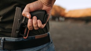 Man hides a handgun behind his back in his waistband