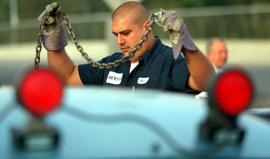 Tow truck driver hooks up a Ford Excursion