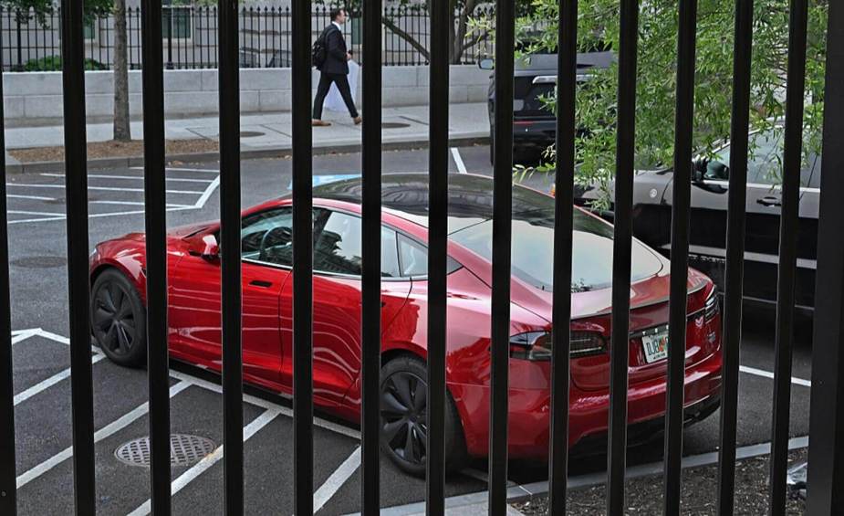 The red Tesla Model S reportedly belonging to Donald Trump behind a fence line at the White House