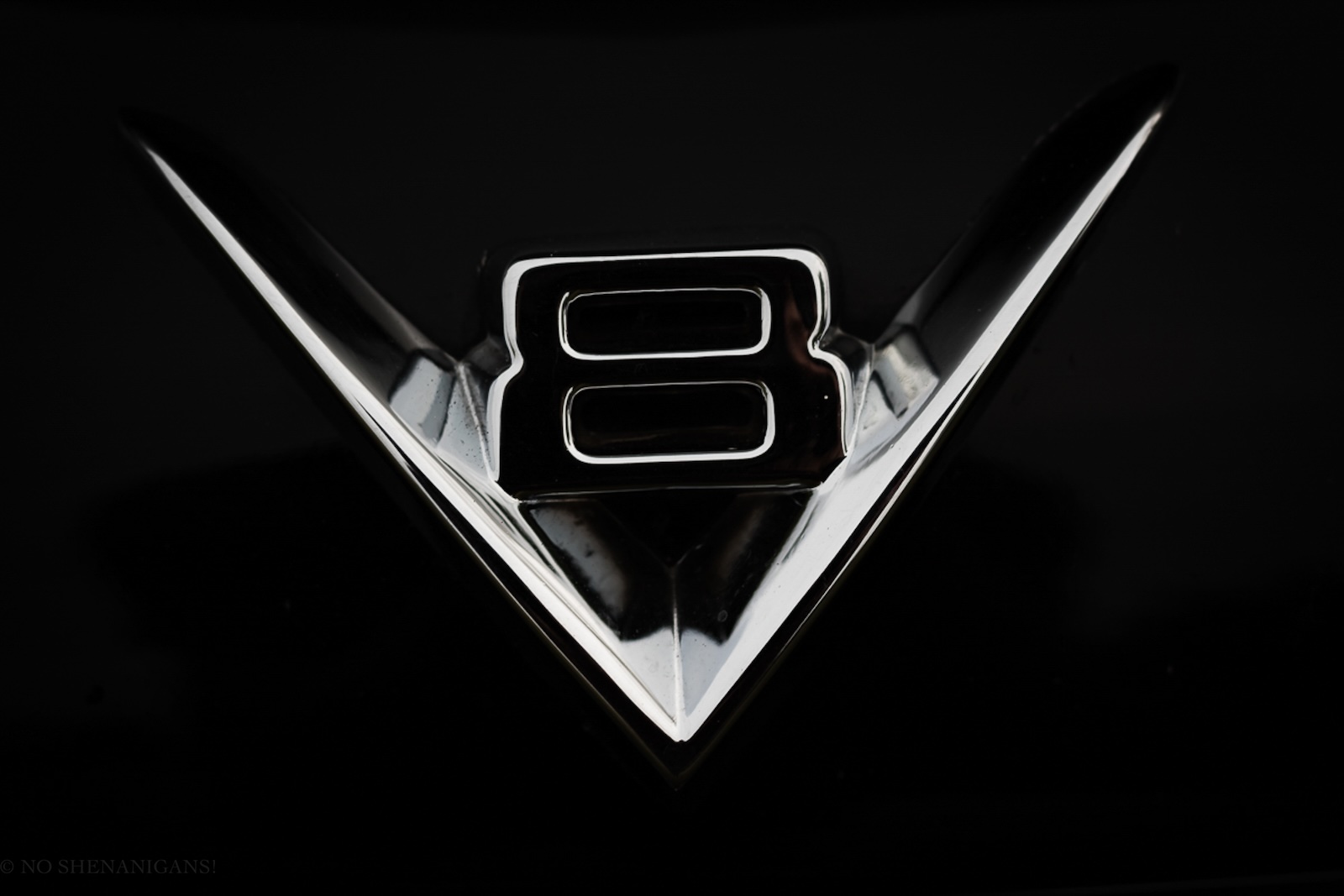 Chrome logo on the hood of a black, V8, half-ton pickup truck