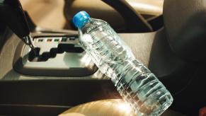 A plastic bottle of water laying inside a car