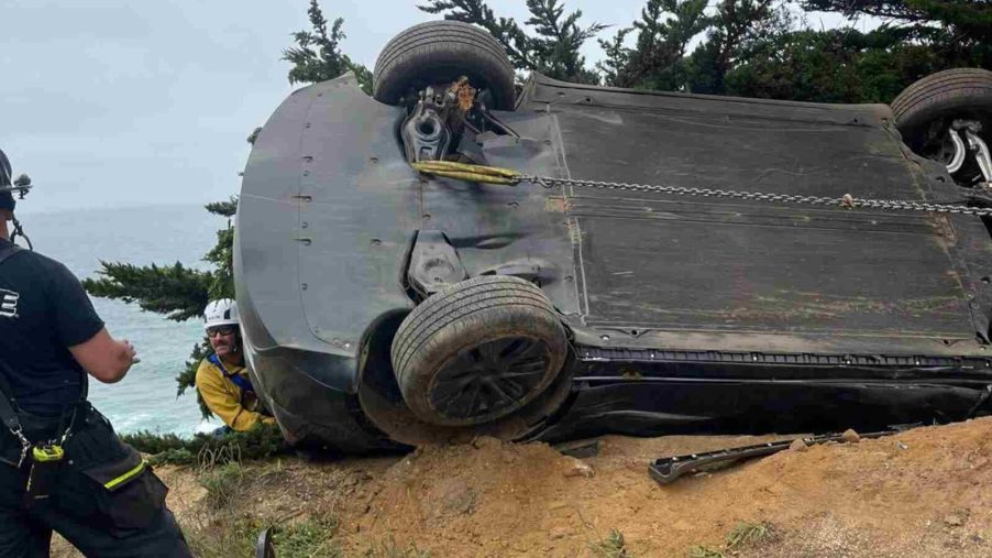 A Tesla EV dangles above Devil's Slide while Cali firefighters work to rescue the driver