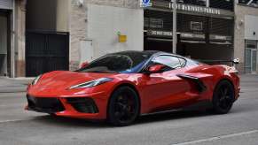 A red Corvette C8 parked on a city street in left front angle view