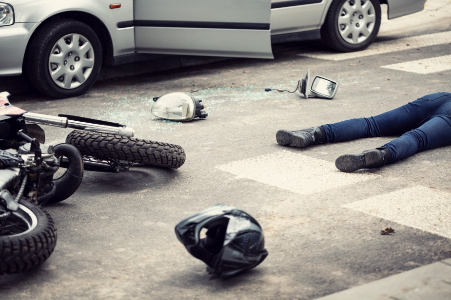 A motorcycle wreck with a man in the road