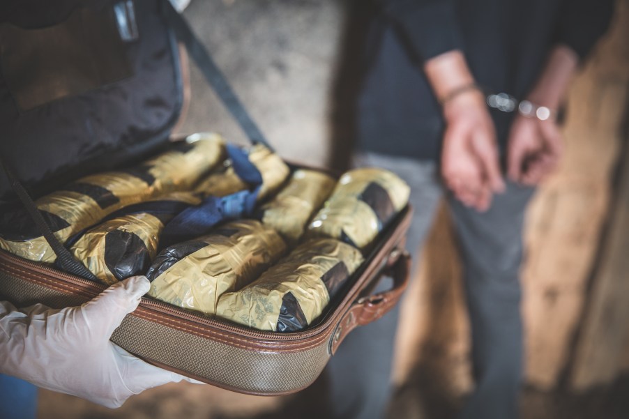 A police officer arresting a man with drugs