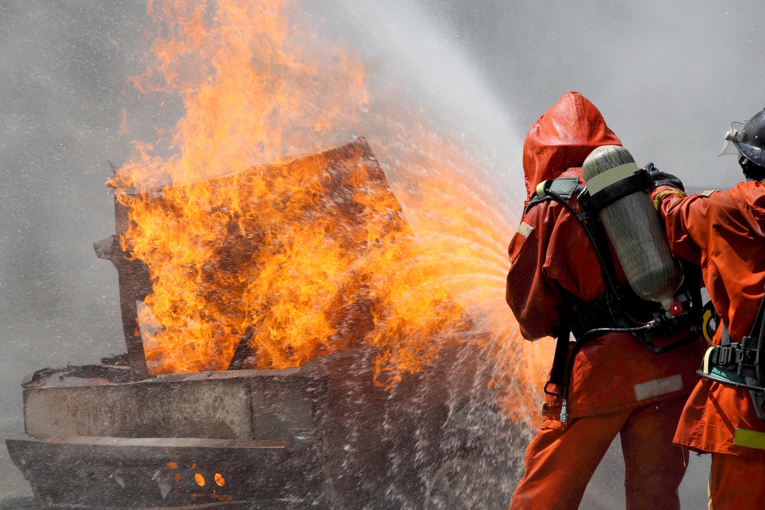 firefighters trying to put a burning truck out