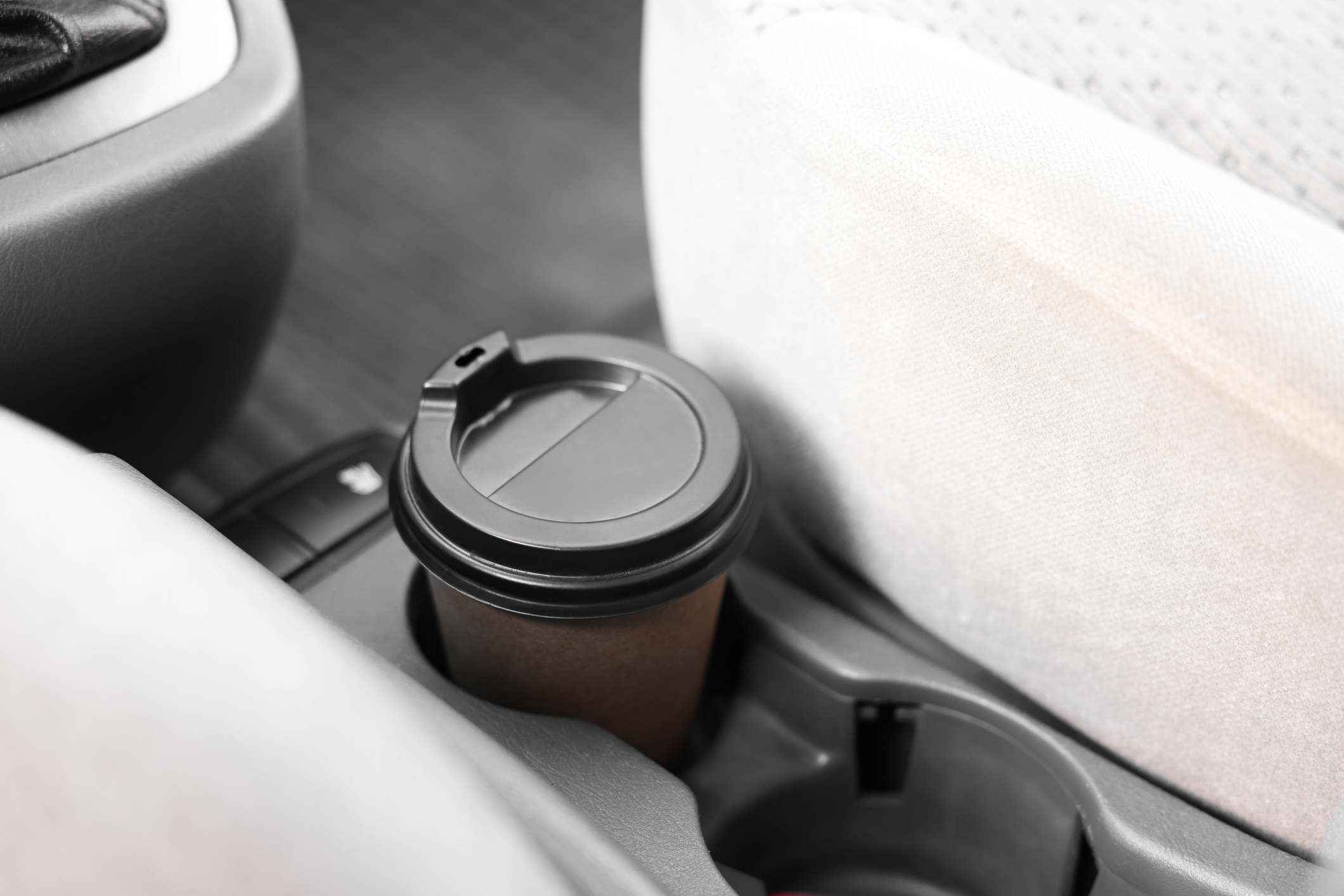 Coffee in a car's built-in center console cupholder.