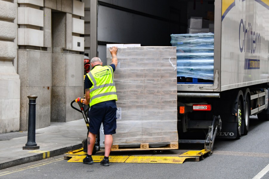 A man loading pallets in semi-truck