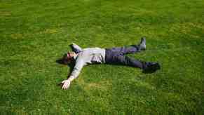 Man sleeping on a lawn spread-eagled.