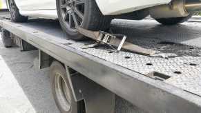 Stolen car bought by dealership sitting on tow truck trailer