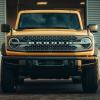 A yellow Ford Bronco shows off its fascia.