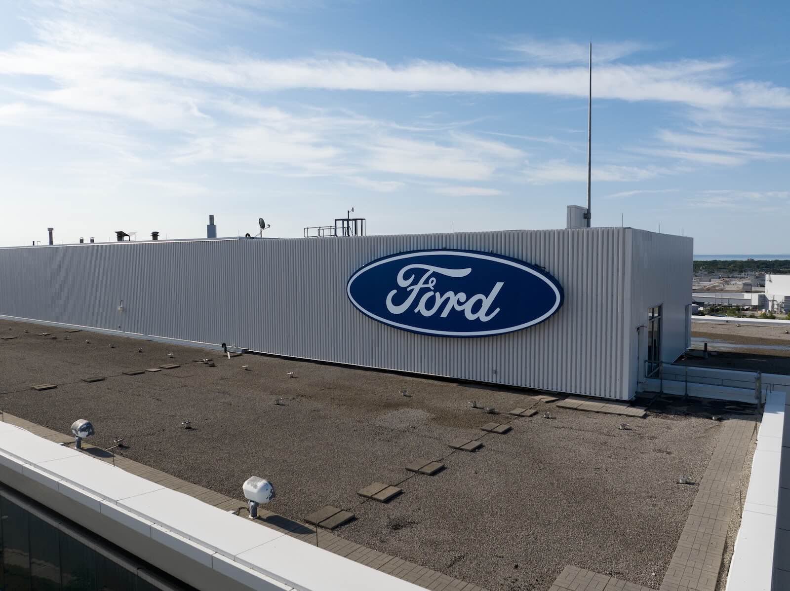 The Ford Blue Oval logo visible on the rooftop of an office building.