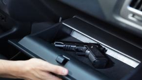 A person reaches for a gun in their glovebox, something that could land them in big trouble during a DUI arrest.