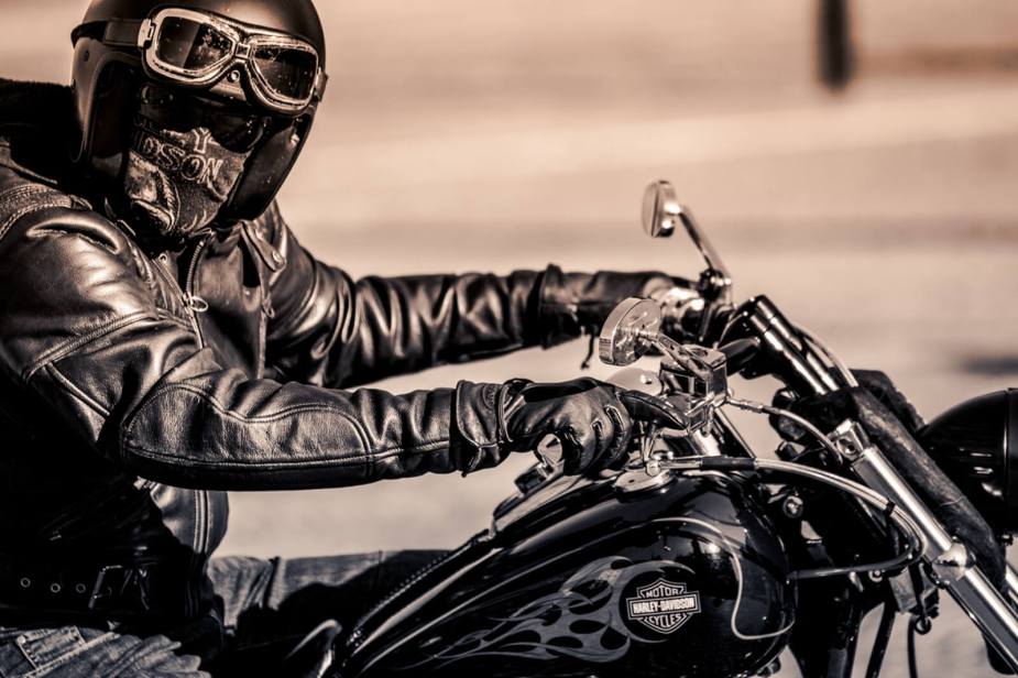 A Harley-Davidson rider takes a ride on their Dyna in a black-and-white image.