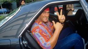 Hulk Hogan, legendary wrestler and car collector smiles in the back seat of a car.