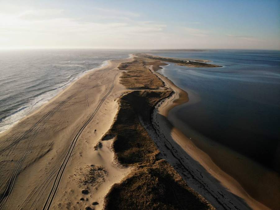 Set of Mercedes G Wagon tracks on abandoned Nantucket beach at sunset.