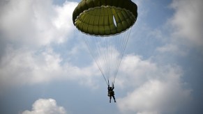 Pilot parachuting to the ground after ejecting from F-35 fighter jet