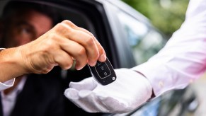 Stealth wealth billionaire hands the keys of his car to a chauffeur.