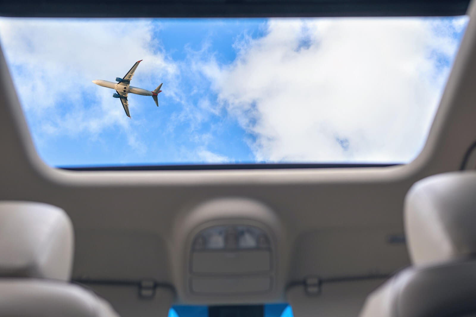 A sunroof shows the sky through a roofline.