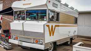 White and tan Winnebago RV parked in a. driveway.