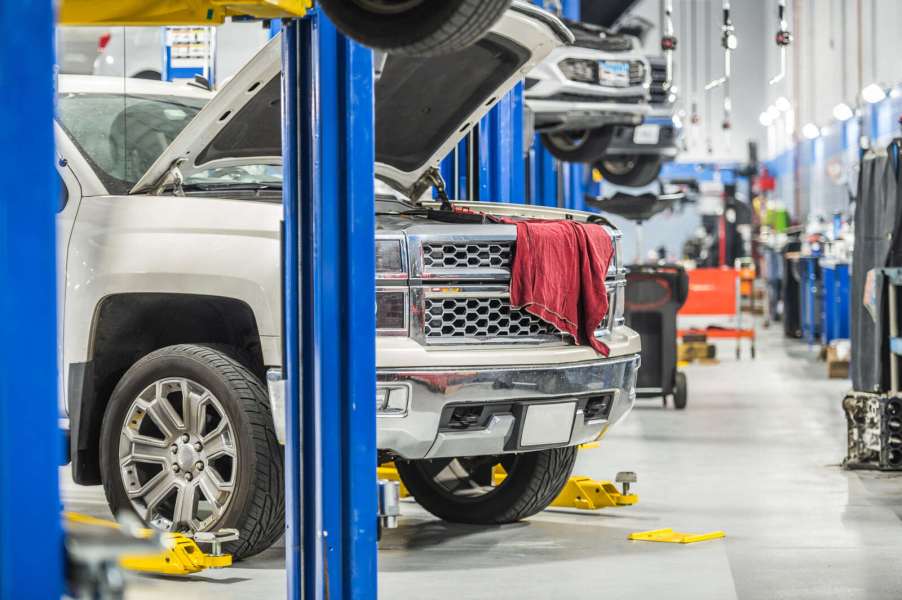Car dealership service bays with a large pickup truck parked in the foreground lift