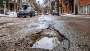 A pothole in a city street illustrates how damaging these menaces can be for your car's suspension, tires, and wheels.