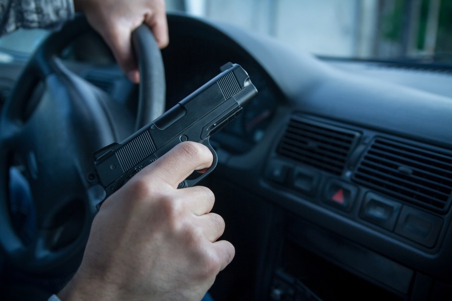 A driver holding a gun