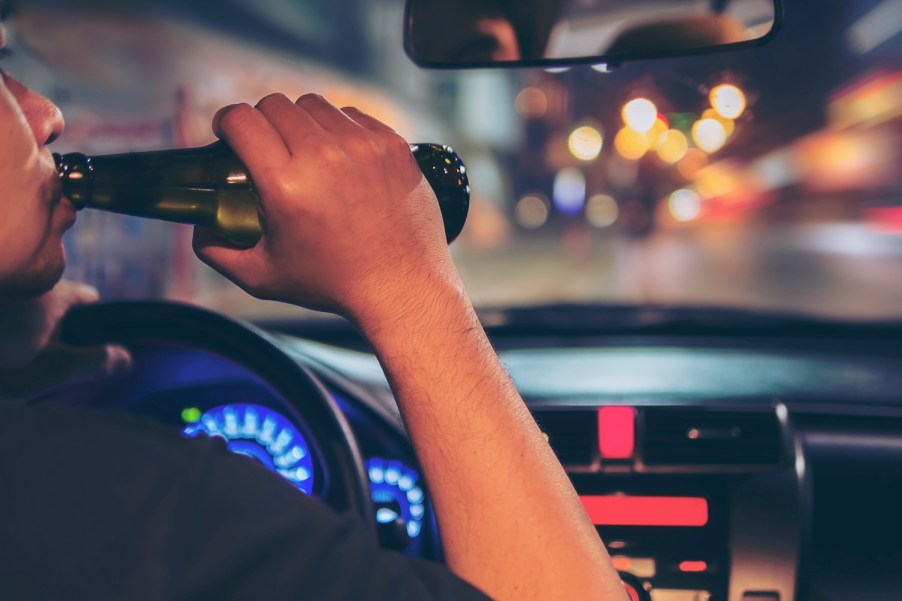 A man drinking a beer while driving