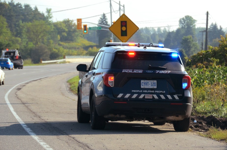 A police SUV on the side of the road with its lights on