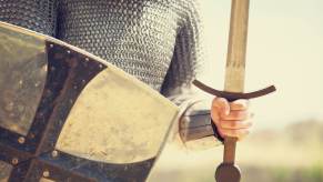 A medieval knight in close view of torso holding a shield and sword