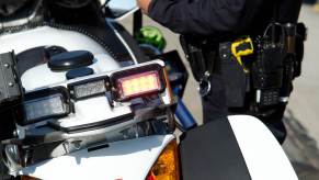 A police officer stands next to his motorcycle in close view