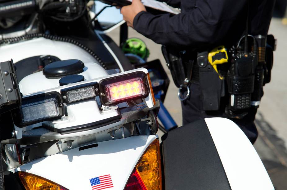 A police officer stands next to his motorcycle in close view