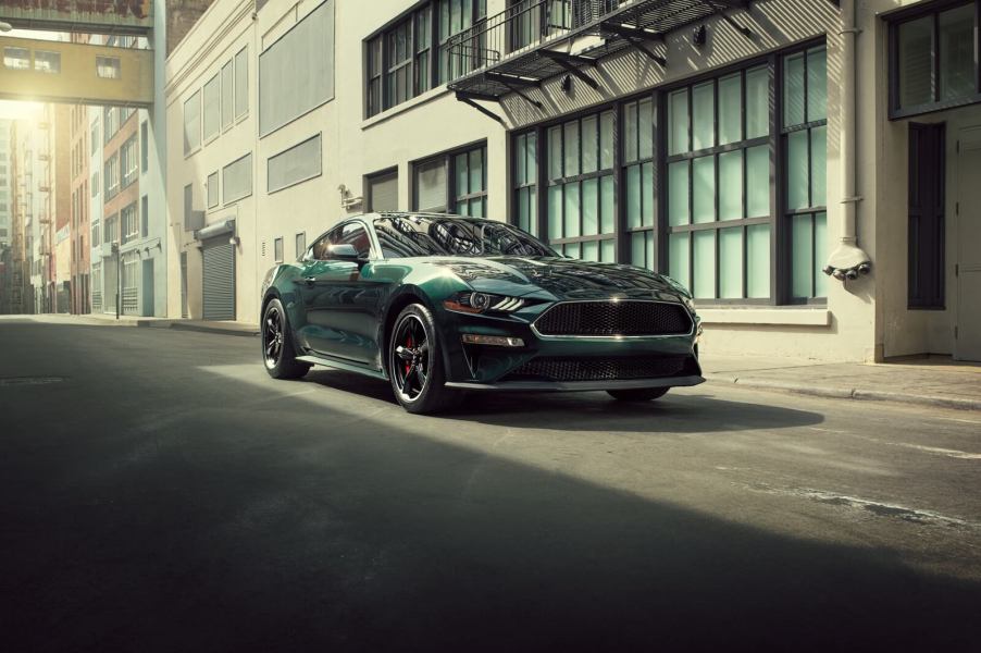 A Dark Highland Green Ford Mustang Bullitt on city streets.