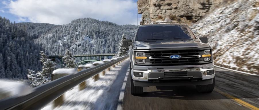 A 2025 Ford F-150 cruises around a mountain pass.
