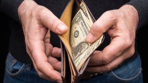 The hands of a car owner paying a mechanic $37 to fix a car.