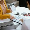 A woman calculates a car buyer's monthly car payment.