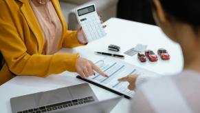 A woman calculates a car buyer's monthly car payment.