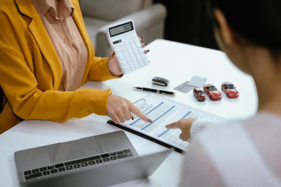 A woman calculates a car buyer's monthly car payment.
